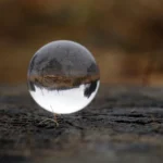 Innere Widerstände gegen dich selbst erkennen: Der geheime Schlüssel zu innerem Frieden. Zu sehen ist eine Glasmurmel, in der sich eine Landschaft spiegelt